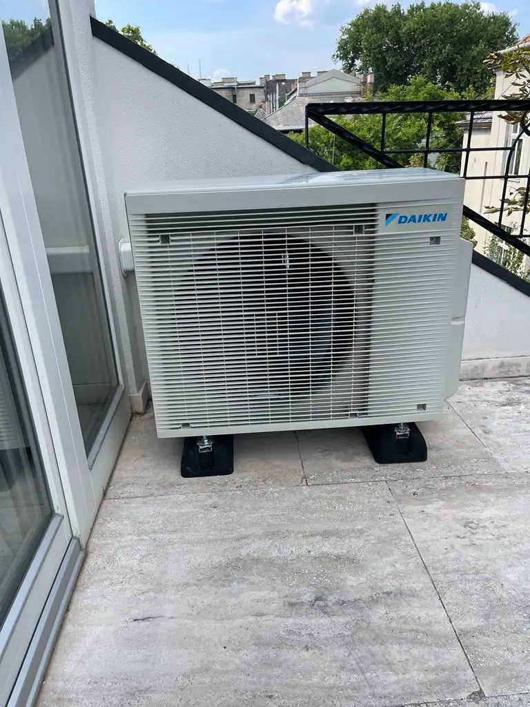 Daikin kültéri egység egy tetőterasz sarkában, gumibakokon