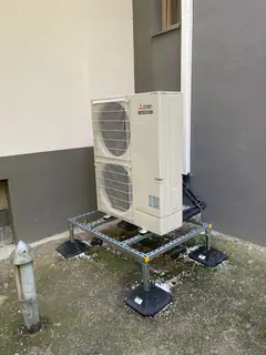 Mitsubishi Electric kültéri egység acél állványon egy ház fala mellett – Verőce
